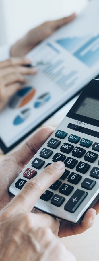 Person holding a calculator and a charts